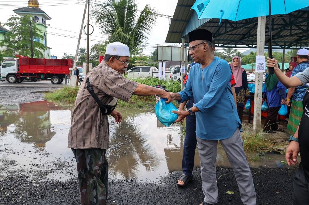 A Permatang Pauh constituent receives a fresh chicken from the prime minister’s special officer at a mosque in Bukit Mertajam, Penang for Raya. — Bernama file pic