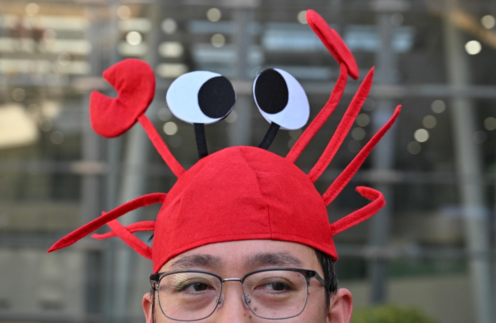 A man wears a lobster hat that represent the OpenClaw logo, an open-source AI assistant, at the Baidu headquarters in Beijing March 11, 2026. — AFP pic