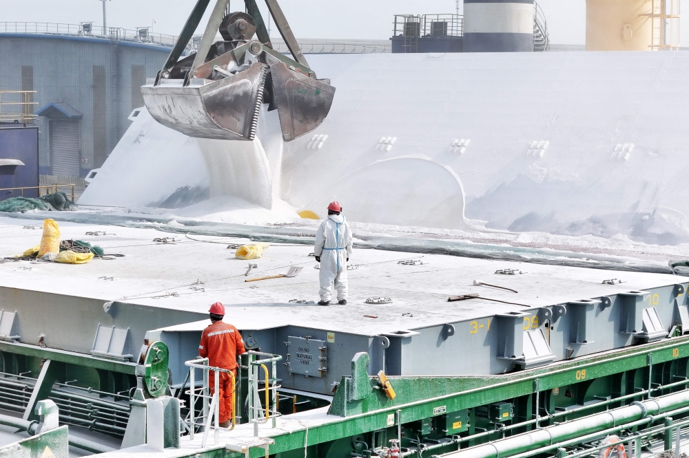 Fertiliser is loaded onto a cargo ship at a port in Yantai, in China’s eastern Shandong province on March 16, 2026. — CN-STR/AFP pic 