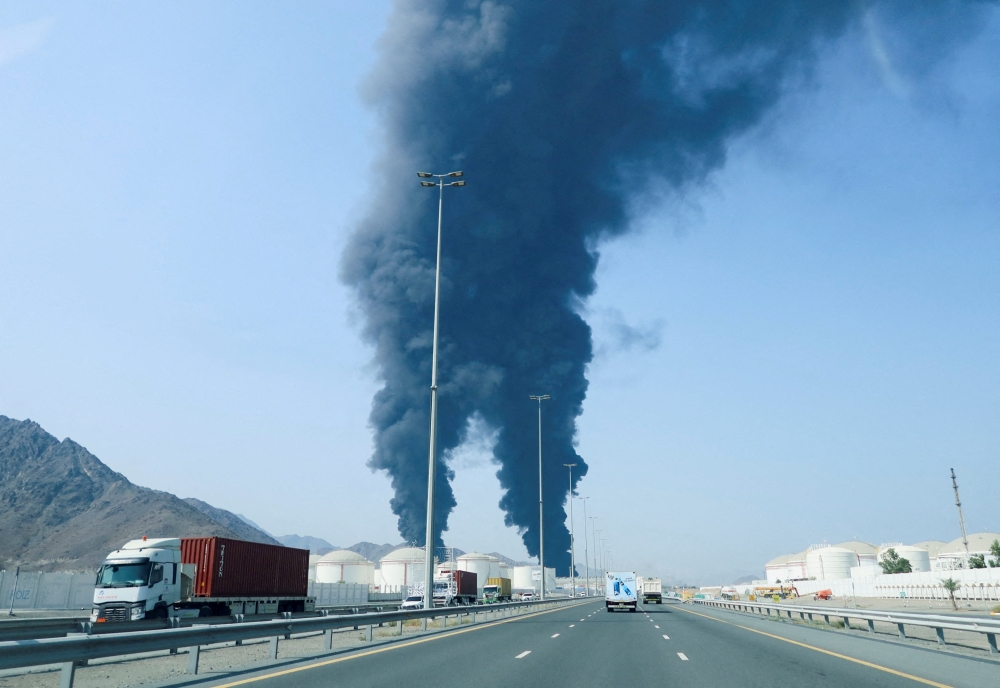 Smoke rises in the Fujairah oil industry zone, caused by debris after interception of a drone by air defenses, according to the Fujairah media office, amid the US-Israel conflict with Iran, in Fujairah, United Arab Emirates, March 14, 2026. — Reuters pic