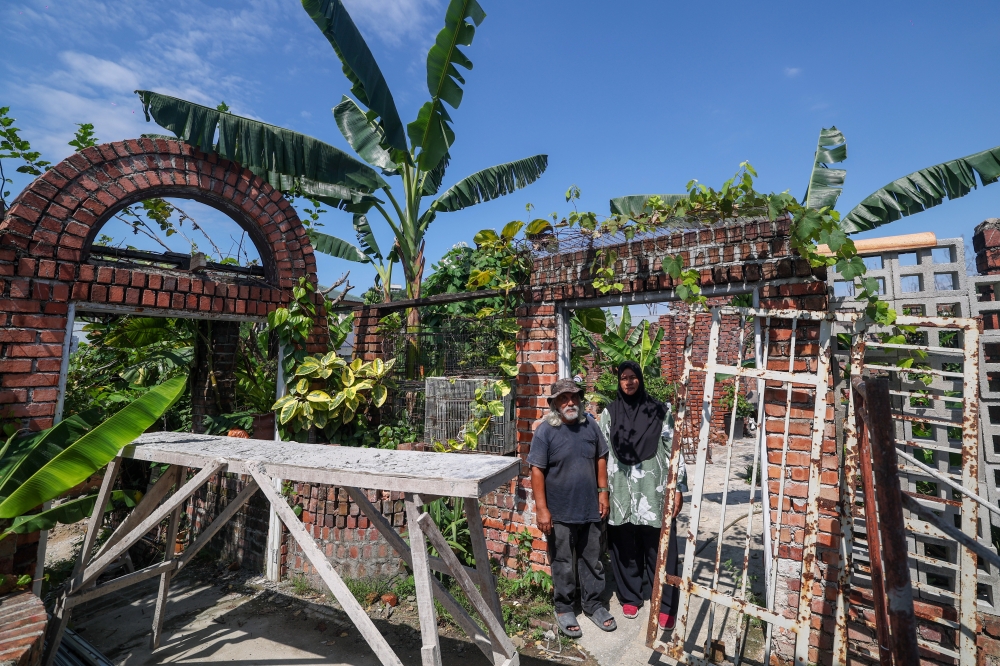 Mohamad Nasir Abd Hamid, 70, with his wife, Aliyah Ismail, 58, in front of their former house which was destroyed due to the gas explosion tragedy in Taman Putra Harmoni last year, when met in Kampung Kuala Sungai Baru March 13, 2026. — Bernama pic