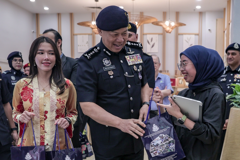 Johor police chief Datuk Ab Rahaman Arsad (centre) hands out gifts to visitors at the launch of Ops Selamat 26 Hari Raya Aidilfitri 2026 in Bukit Indah on March 18, 2026. — Bernama pic