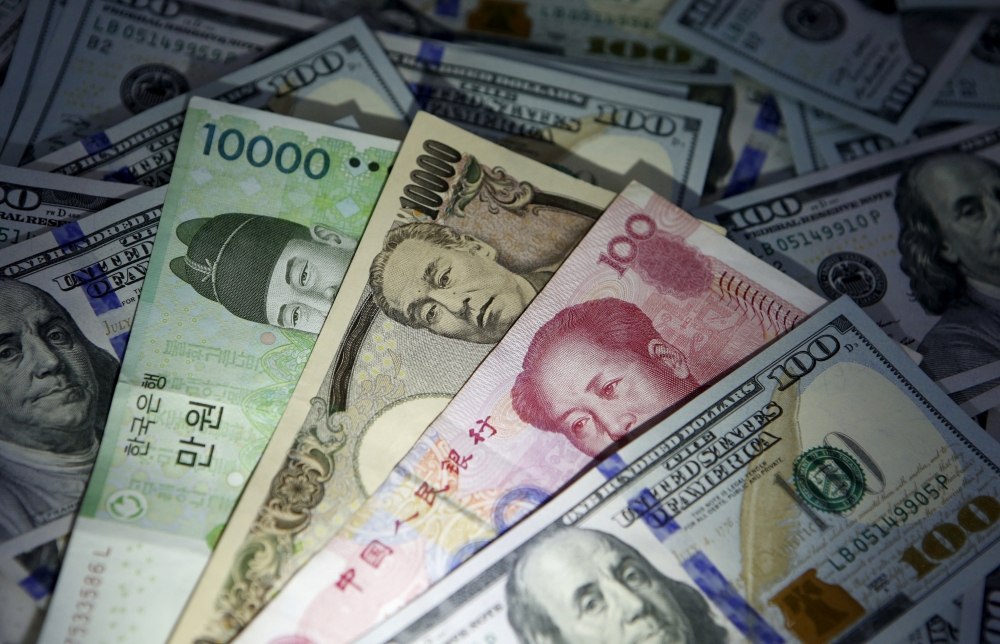 South Korean won, Chinese yuan and Japanese yen notes are seen on US 100 dollar notes in this picture illustration taken in Seoul December 15, 2015. — Reuters pic 