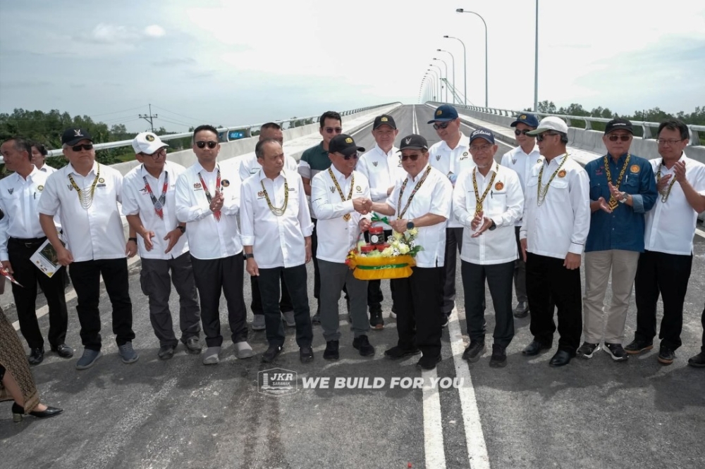 Deputy Premier Datuk Amar Douglas Uggah Embas (5th right) receives a memento from Cassidy after the Sungai Krian Bridge soft launch ceremony March 19, 2026. — Picture via Facebook/JKR Sarawak