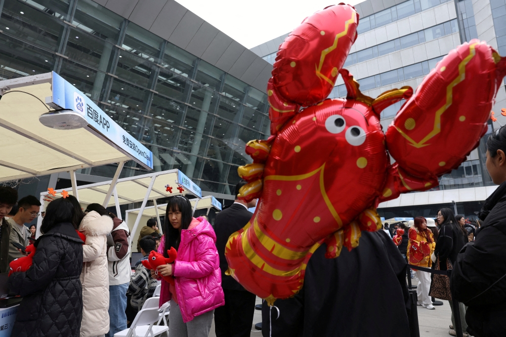 Participants line up near a lobster-shaped balloon to set up and install OpenClaw, an open-source AI agent, outside the Baidu offices in Beijing March 17, 2026. — Reuters pic