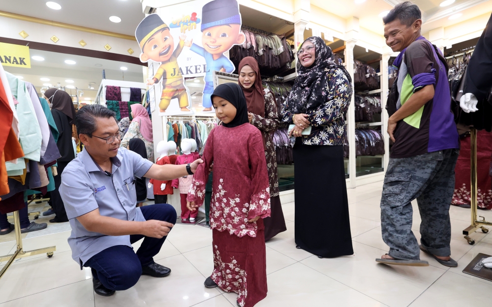 Minister in the Prime Minister's Department (Sabah and Sarawak) Datuk Mustapha Sakmud (left) taking children from underprivileged families around the Sepanggar area to buy Hari Raya clothes at Jakel Alam Mesra in Kota Kinabalu March 19, 2026. — Bernama pic