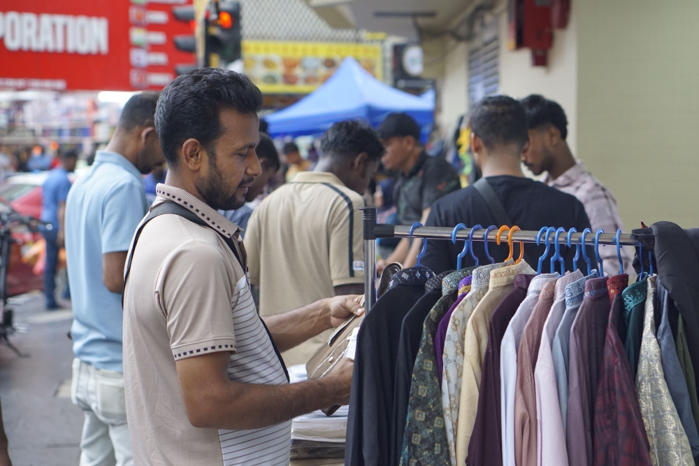 A customer shops for Baju Raya along Jalan Tun Tan Siew Sin in Kuala Lumpur ahead of Hari Raya celebrations. — Picture by Arif Zikri