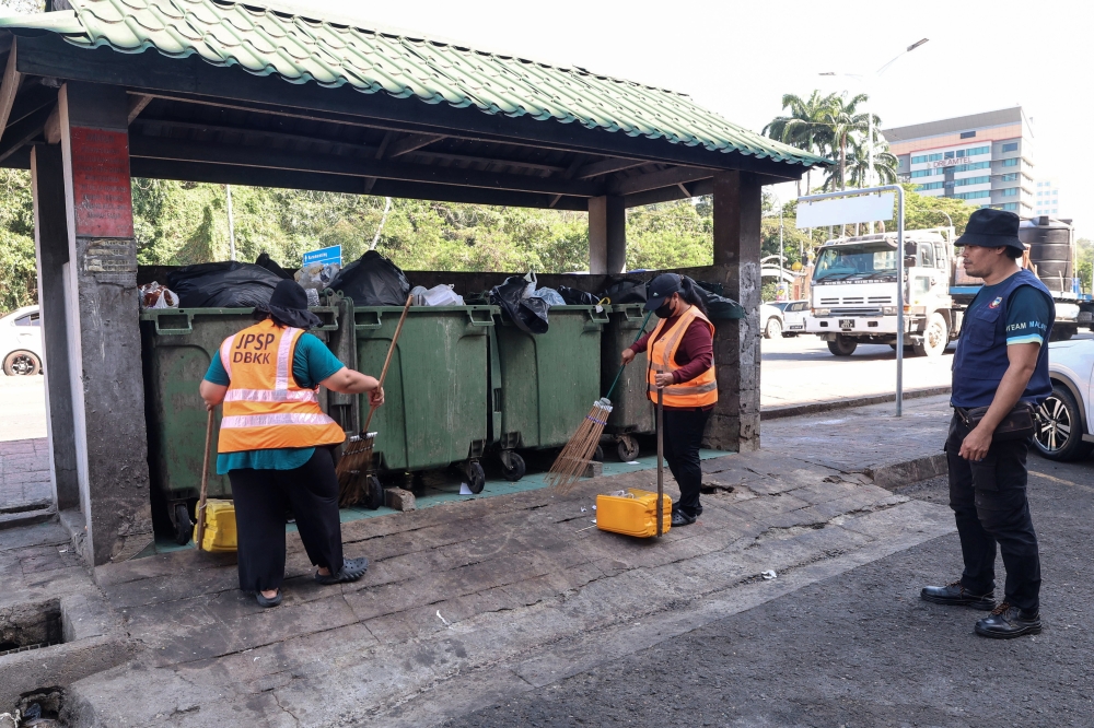 Kota Kinabalu City Hall (DBKK) cleaning officer Wellson Kondu (right) monitors cleaning work at the garbage collection point along the Ramadan Bazaar at Lintasan Deasoka March 17, 2026. — Bernama pic