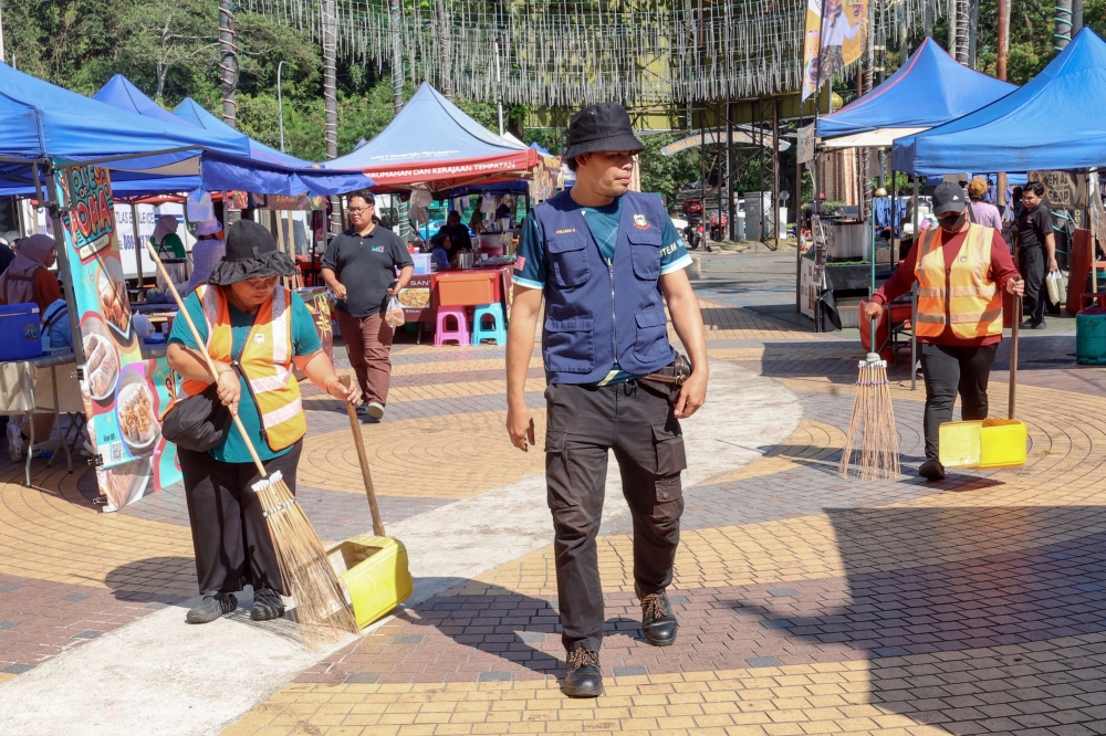 Kota Kinabalu City Hall (DBKK) cleaning officer Wellson Kondu monitors the level of cleanliness around the vendors' stalls at the Ramadan Bazaar at Lintasan Deasoka in Sinil March 17, 2026. — Bernama pic