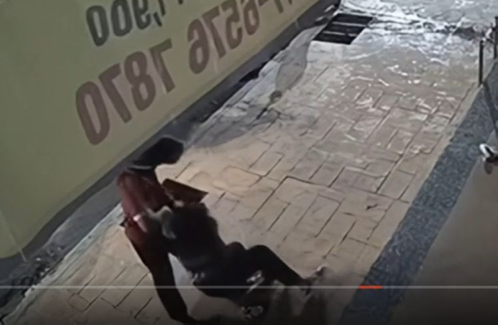 A still from a surveillance camera shows a man dragging a woman on the ground after punching, kicking, and kneeing her in the head, reportedly in Melaka.