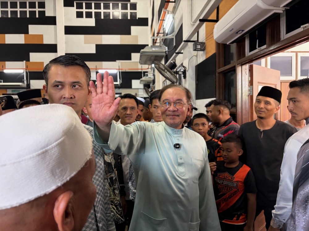 Prime Minister Datuk Seri Anwar Ibrahim waves during a gathering with the community in Permatang Pauh on March 20, 2026. — Picture by Opalyn Mok