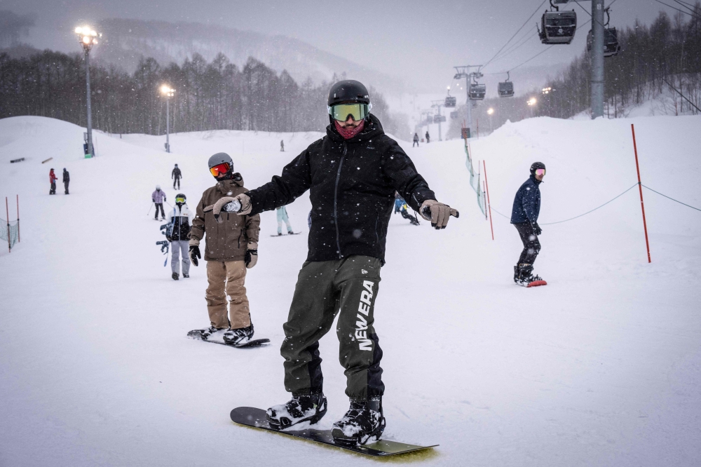 This picture taken on February 19, 2026 shows foreign tourists skiing and snowboarding at the Niseko Hanazono ski resort in Kutchan, Hokkaido prefecture. Beneath the powder snow at internationally popular Japanese ski resort Niseko, anxiety is mounting among residents over soaring prices and a massive influx of overseas workers. — AFP pic 