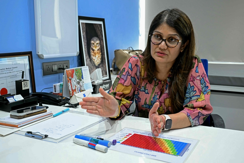 This photograph taken on March 17, 2026 shows obesity doctor and consultant Swati Pradhan explaining a body mass index (BMI) chart at her clinic in Mumbai. — AFP pic