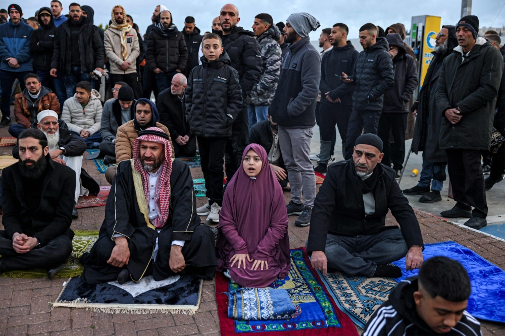 Muslim worshippers gather outside the Jerusalem old city walls on March 20, 2026 to attend attend the early morning prayers for Eid al-Fitr, marking the end of the holy month of Ramadan. — AFP pic
