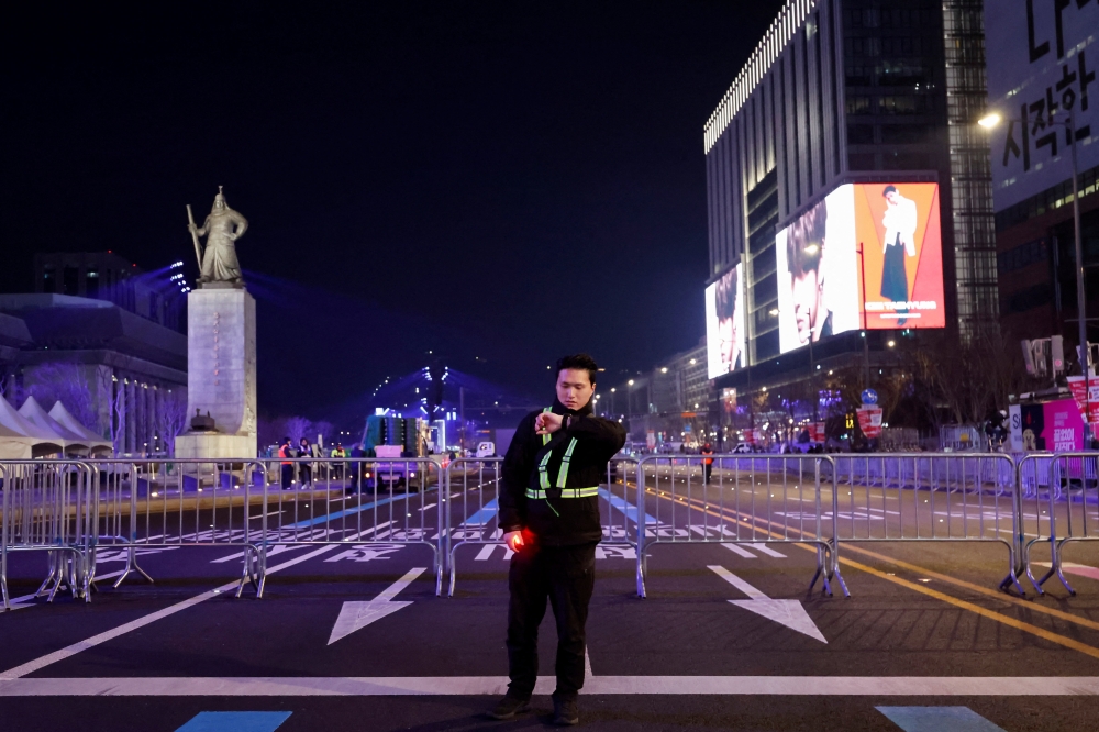 A worker patrols at the temporarily restricted Gwanghwamun square that will be used for ‘BTS The Comeback Live Arirang’ concert, Kpop boy band BTS’ first performance in more than three years since completing mandatory military service, the night before the concert in Seoul, South Korea, March 20, 2026. — Reuters pic