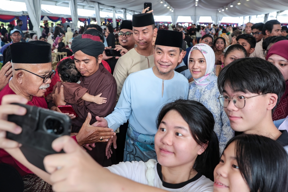 Menteri Besar Datuk Onn Hafiz Ghazi (centre) and his wife Datin Sharmin Fazlina Mohd Shukor (3rd, right) take a selfie with some of the guests who attended the Johor Menteri Besar's Aidilfitri Open House at his official residence in Saujana, Johor Bahru March 21, 2026. — Bernama pic