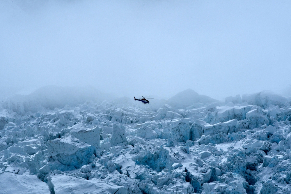 A helicopter flies over the Khumbu glacier in Nepal’s Mount Everest region, Solukhumbu district, northeast of Kathmandu, May 2, 2021. — AFP pic
