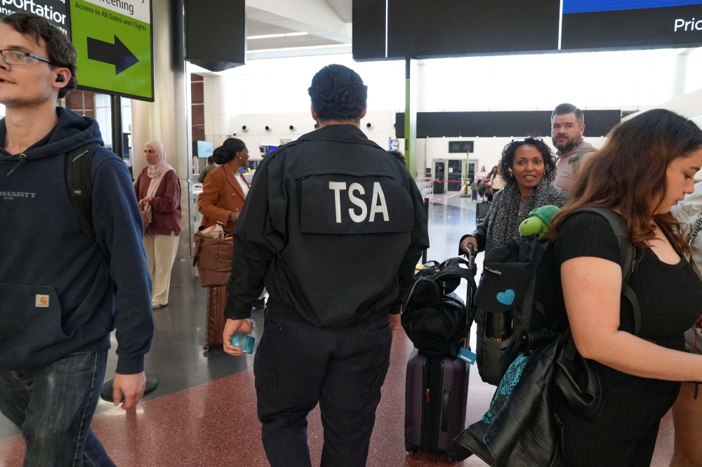 A TSA agent walks through as passengers wait in long TSA lines as a partial government shutdown continues, at Hartsfield-Jackson Atlanta International Airport in Atlanta, Georgia March 20, 2026. The TSA, which operates under the authority of DHS, comprises about 65,000 employees, according to its website. — Reuters pic  
