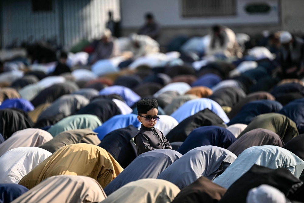 A child looks on as Muslim devotees offer Eid al-Fitr prayers, which marks the end of the Islamic holy fasting month of Ramadan, in Rawalpindi, Pakistan on March 21, 2026. — AFP pic