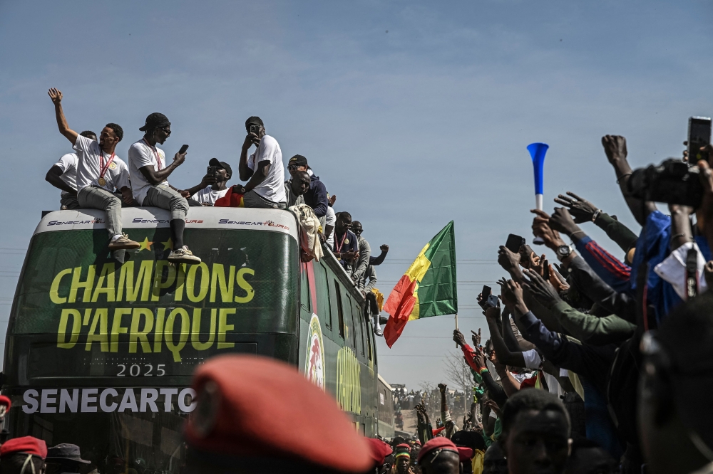 Senegal’s football team players greet a crowd of supporters while riding on an open bus during a trophy parade in the streets of Dakar on January 20, 2026, only to be later stripped of its Africa Cup of Nations title that was subsequently awarded to Morocco. — AFP pic