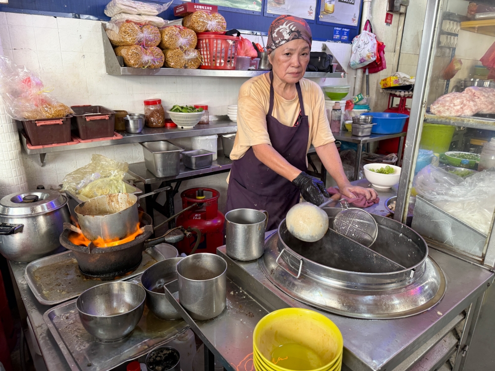 It’s hot and hard work to cook non-stop behind a hot stove. — Picture by Lee Khang Yi