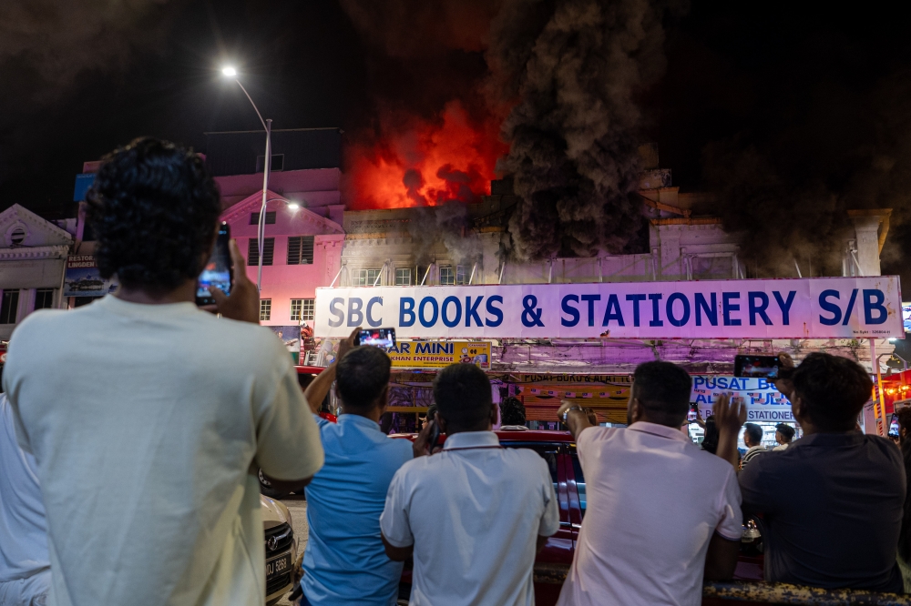 Fire and Rescue Department (JBPM) personnel in Negeri Sembilan are actively working to extinguish a fire at a two-storey bookshop on Jalan Datuk Syeh Ahmad last night. — Bernama pic 