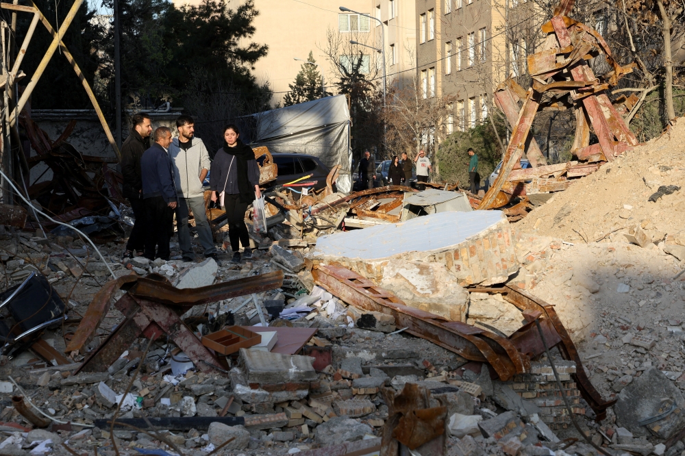 People look at a destroyed building following a strike, amid the US-Israeli conflict with Iran, in Tehran, Iran, March 21, 2026. — Reuters pic