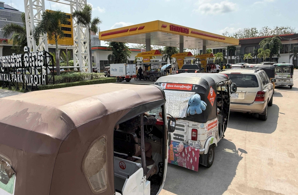 Vehicles queue up at a fuel station in Phnom Penh on March 23, 2026. A major energy supplier in Cambodia has said it will halt sales of liquefied petroleum gas from the start of next month due to supply disruptions resulting from the Middle East war. — AFP pic