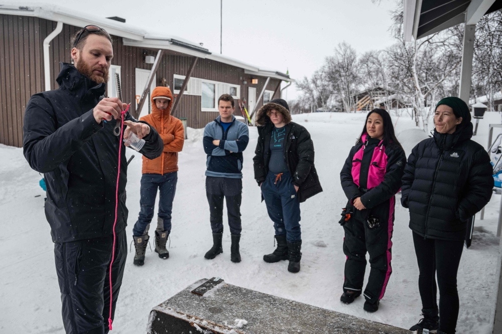 Erik Wurz, coordinator of the programme run by the Finnish Scientific Diving Academy, shows participants how to collect underwater ice samples. — AFP pic