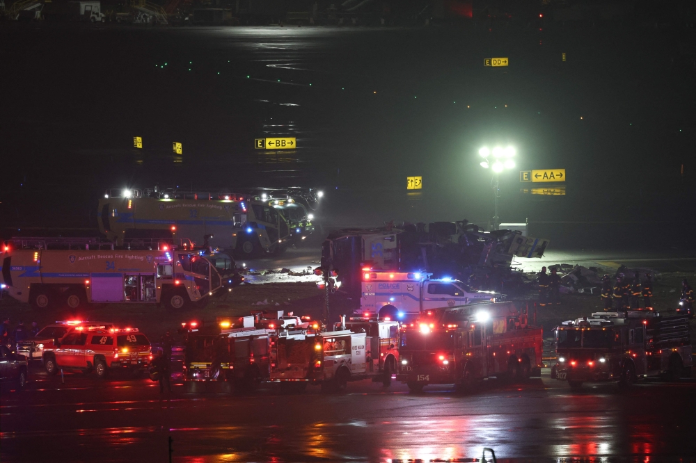 Emergency personnel respond to an Air Canada Express CRJ-900 after colliding with a Port Authority fire truck at LaGuardia Airport in New York, on March 23, 2026. — AFP pic