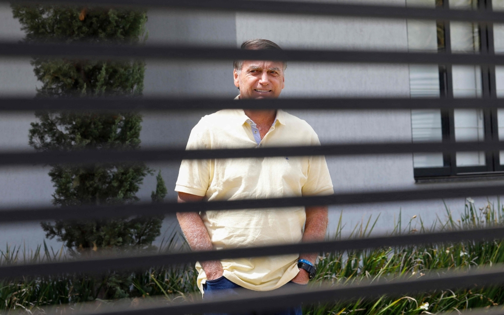 Former Brazilian President Jair Bolsonaro gestures from his residence in Brasilia on September 3, 2025. — AFP file pic