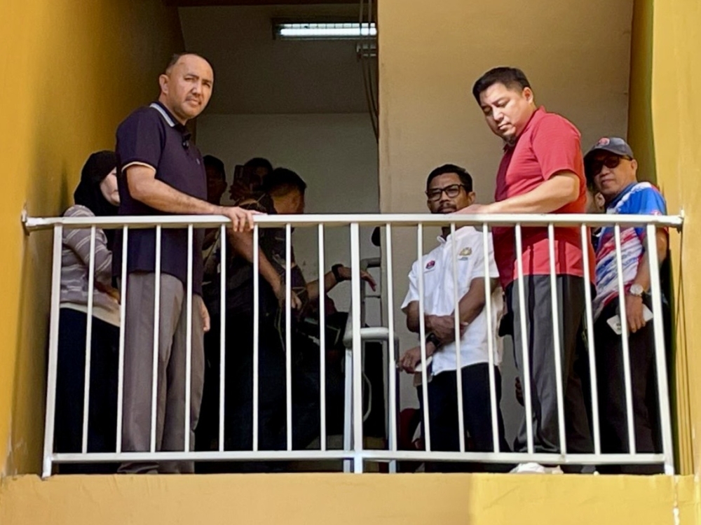 Johor Housing and Local Government Committee chairman Datuk Mohd Jafni Md Shukor (left) inspects the existing guardrails at Taman Desa Mutiara PPR in Johor Bahru on March 24, 2026 after a boy, 9, suffered extensive injuries from falling. — Picture by Ben Tan