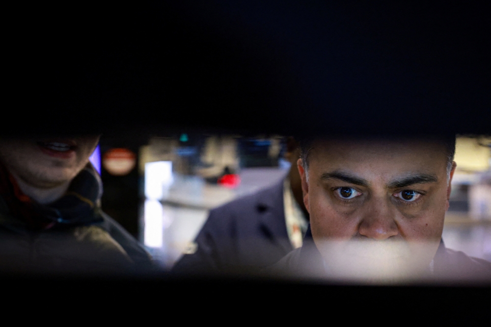 Traders work on the floor at the New York Stock Exchange. US stocks have outperformed global markets since the conflict began, but analysts warn risks remain if it drags on. — Reuters pic