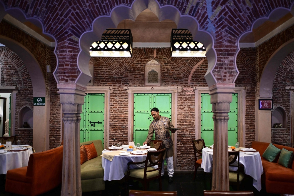 This photograph taken on February 2, 2026 shows a hospitality staff arranging tableware at the Dharampura Haveli, an 18th-century haveli-turned-heritage hotel in the old quarters of Delhi. — AFP pic
