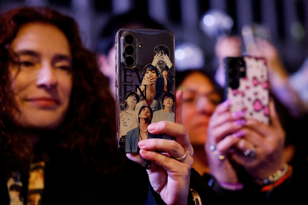 A fan of Kpop group BTS uses her smartphone during the ‘BTS The Comeback Live Arirang’ concert in central Seoul March 21, 2026. — Reuters pic