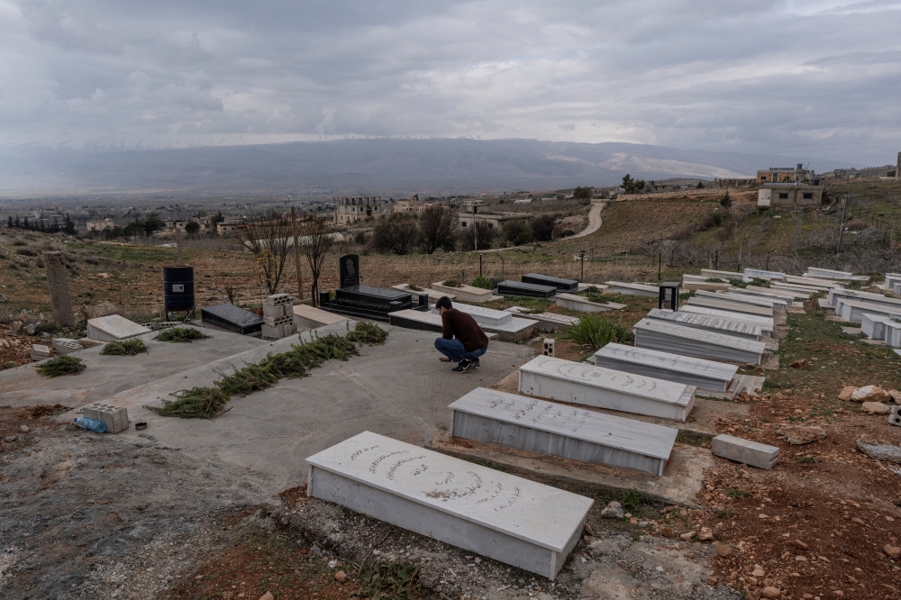 Mohammed Tahhan prays over the grave of his relatives killed by an Israeli strike, following an escalation between Hezbollah and Israel, amid the US-Israeli conflict with Iran, in Chaat, Lebanon, March 23, 2026. — Reuters pic