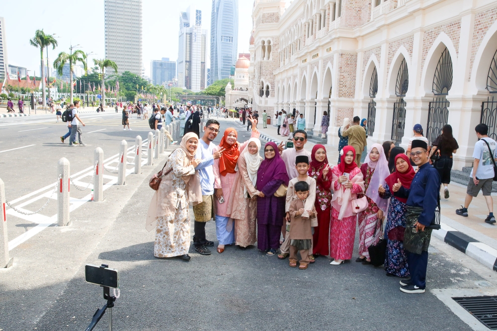 Visitors pose for pictures in front of the Sultan Abdul Samad Building at Dataran Merdeka on the first day of Hari Raya Aidilfitri March 21, 2026. — Picture by Choo Choy May