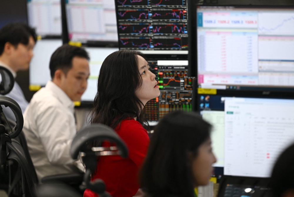 Currency dealers monitor exchange rates in a foreign exchange dealing room at the Hana Bank headquarters in Seoul. Markets rallied after signs of possible de-escalation in the Middle East, with oil prices tumbling on improved sentiment. — AFP pic