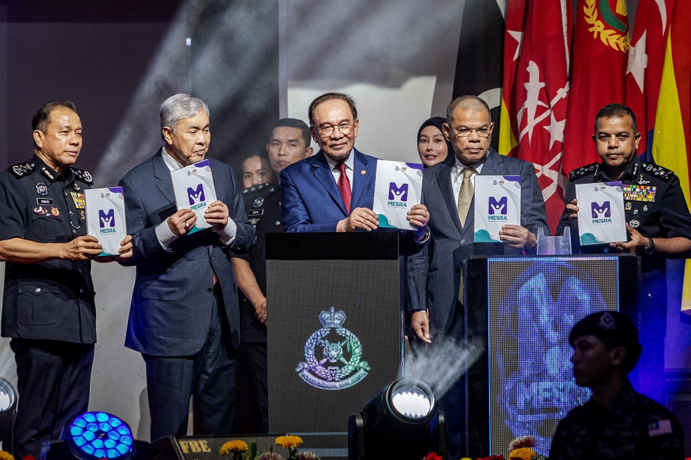 Prime Minister Datuk Seri Anwar Ibrahim and other leaders pose with books during the launch of ‘Buku MESRA PDRM-Modul Kesedaran Jenayah Kanak-Kanak dan Remaja’ at 219th Police Day celebrations at the Police Training Centre (Pulapol) in Kuala Lumpur March 25, 2026. — Picture by Firdaus Latif