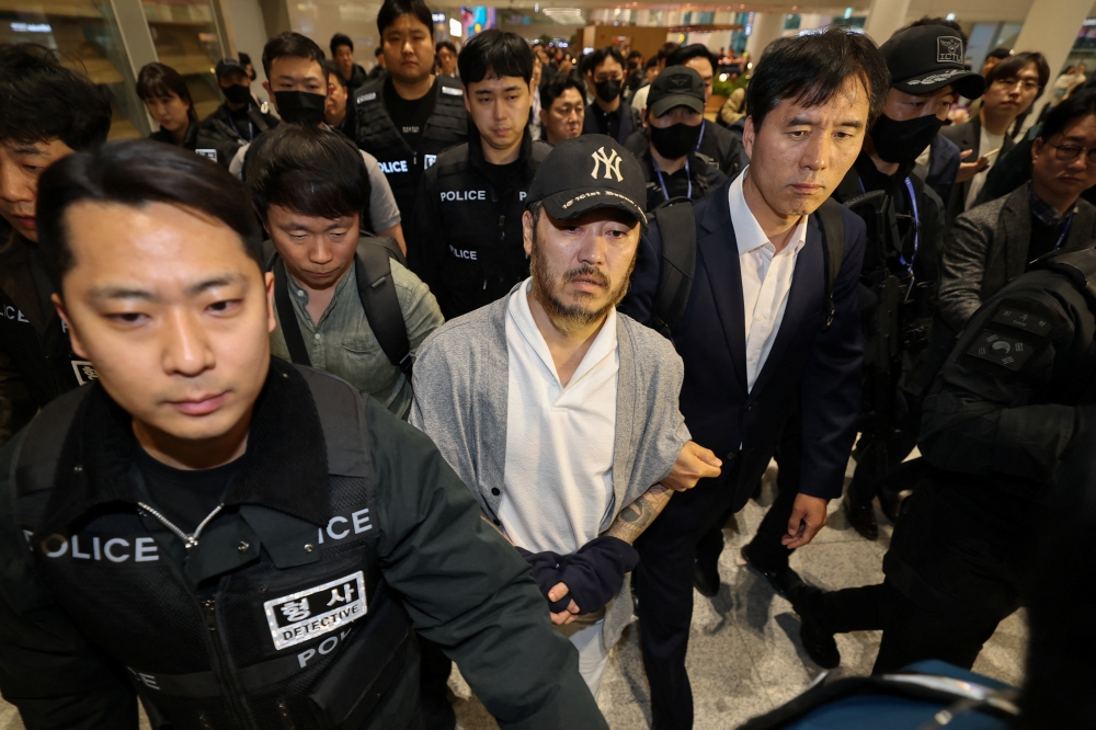 Park Wang-yeol, an alleged ‘drug lord’ who was serving a 60-year term in a Philippines prison for the murder of three South Koreans and who is accused of running a drug trafficking ring in the country from the prison, walks as he is escorted by detectives upon his arrival at the Incheon International airport in Incheon, South Korea, March 25, 2026. — Yonhap pic via Reuters