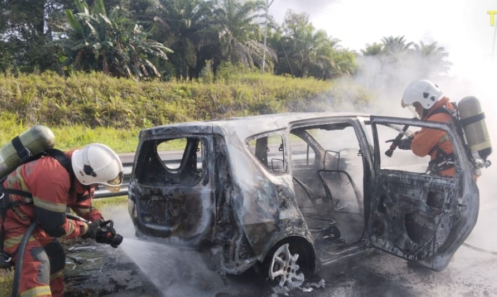 Firefighters extinguishing the flames that engulfed the MPV after the crash. Police will expedite investigations into a fatal accident in Sri Aman that claimed the lives of three family members recently. — Picture courtesy of Fire and Rescue Department