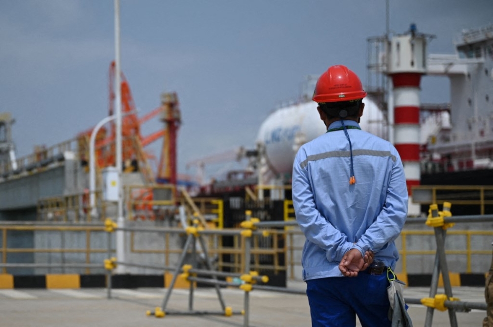 A man stands in front of a cargo ship in the harbour of BASF’s Zhanjiang site. The German chemical giant’s third-largest plant worldwide in Zhanjiang is the largest single investment in the company’s history and is intended to strengthen the group’s presence in China. — AFP pic