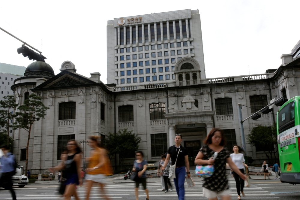 People walk on a zebra crossing in front of the Bank of Korea in Seoul. Officials said the budget will be funded by excess tax revenue and fast-tracked through parliament. — Reuters pic