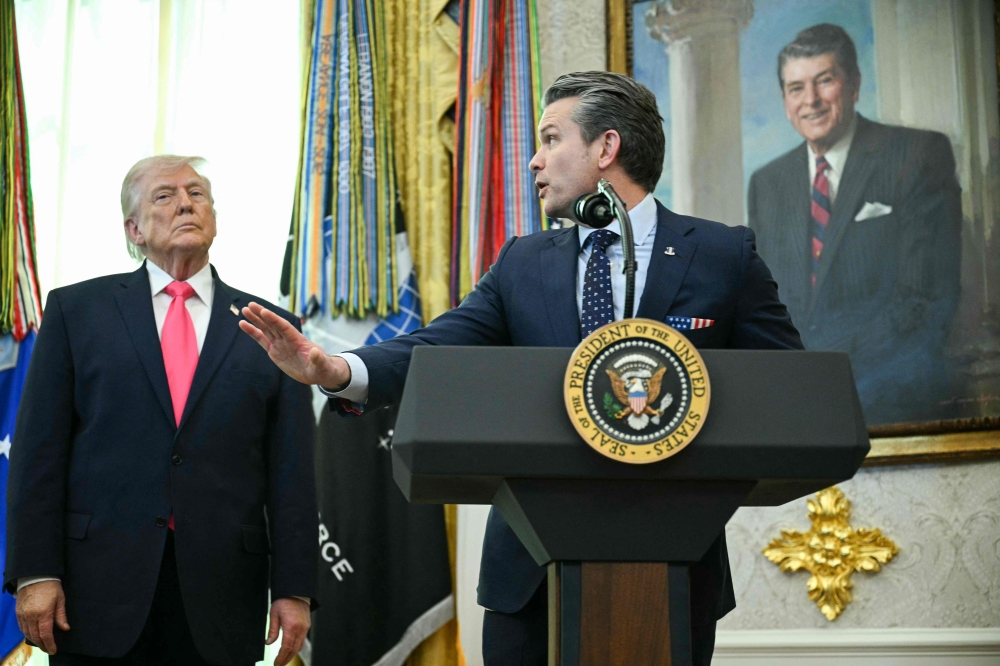 US President Donald Trump looks on as Secretary of Defense Pete Hegseth speaks in the Oval Office of the White House in Washington, DC on March 24, 2026. — AFP pic