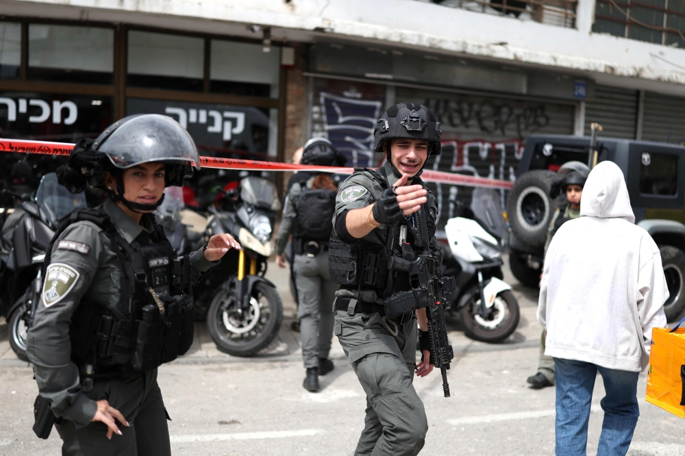 Israeli security forces cordon off the area following a projectile strike on south Tel Aviv on March 26, 2026. — AFP pic