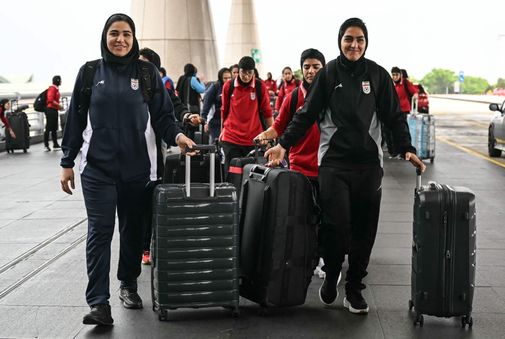 Iranian women’s football team captain Zahra Ghanbari (right) arrives with team mates at the Kuala Lumpur International Airport in Sepang on March 16, 2026 for the next leg of their journey home after abandoning their bid for asylum in Australia. — AFP pic