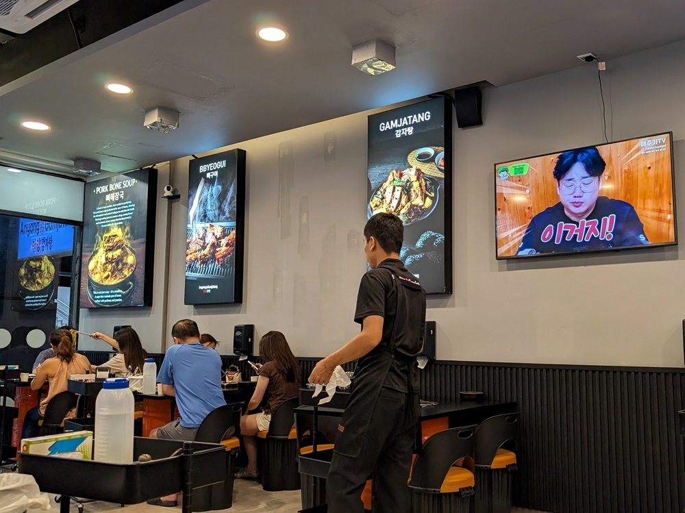 A TV plays what feels like a ‘mukbang’ of someone eating ‘gamjatang’, while you eat. — Picture by Ethan Lau