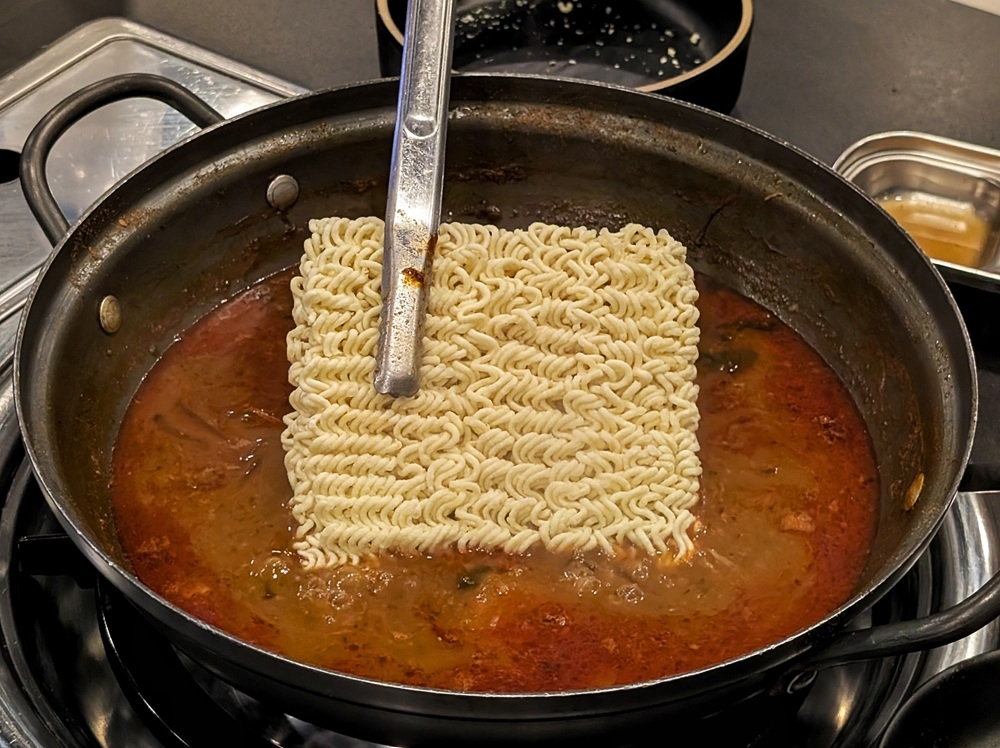 Finish up the soup at the end with your choice of carb; we opted for instant noodles. — Picture by Ethan Lau