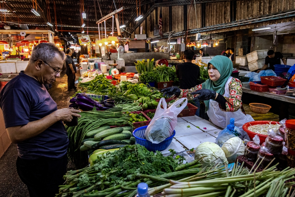 A week after Hari Raya Aidilfitri 2026, vegetable seller Romlah Nasir (right) said she has been selling off the stock that was supplied to her before the festive holiday. — Picture by Firdaus Latif