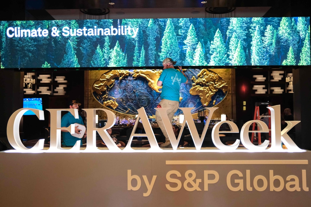 Two men work next to a sign of CERAWeek in Houston, Texas, on March 22, 2026. The world’s largest energy conference wrapped up in Houston yesterday with the crisis caused by the US-Israel war on Iran dominating discussions — but with little to show for it beyond a prevailing sense of uncertainty.  — AFP pic 
